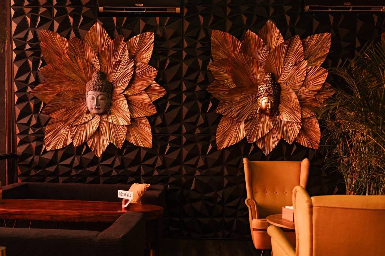 Indoor room at IZZI Rooftop with carved wall panels and armchairs